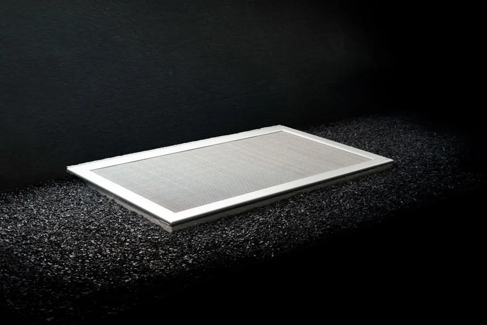 SilverLine Lichtschachtabdeckung mit hellem Rahmen auf dunklem Splitt