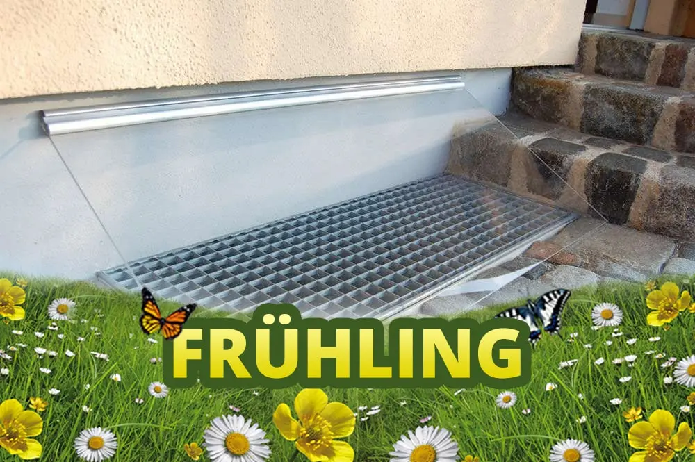 Lichtschacht mit Abdeckung, überlagert vom Schriftzug Frühling auf einer Blumenwiese