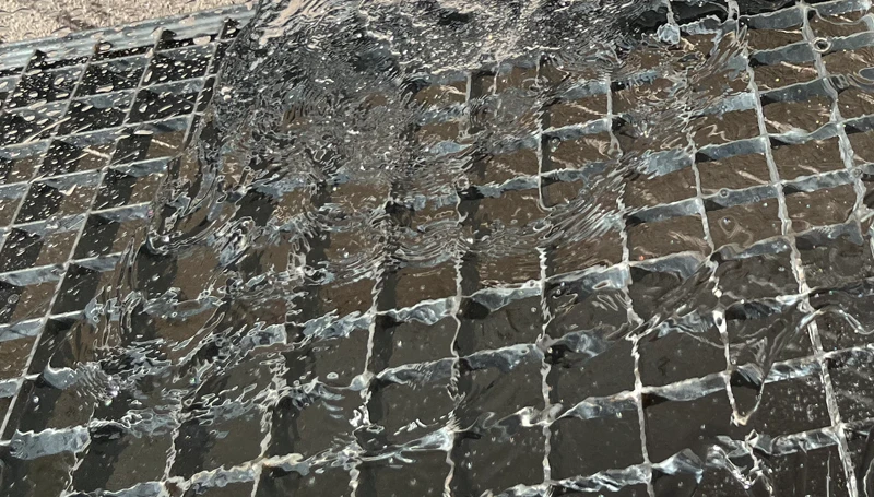 Regenwasser läuft über einen ungeschützten Gitterrost in den Lichtschacht
